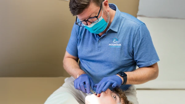 Orthodontist Max Couch, Jr. adjusting a patient's braces